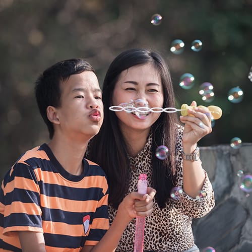 mom and autistic son blowing bubbles
